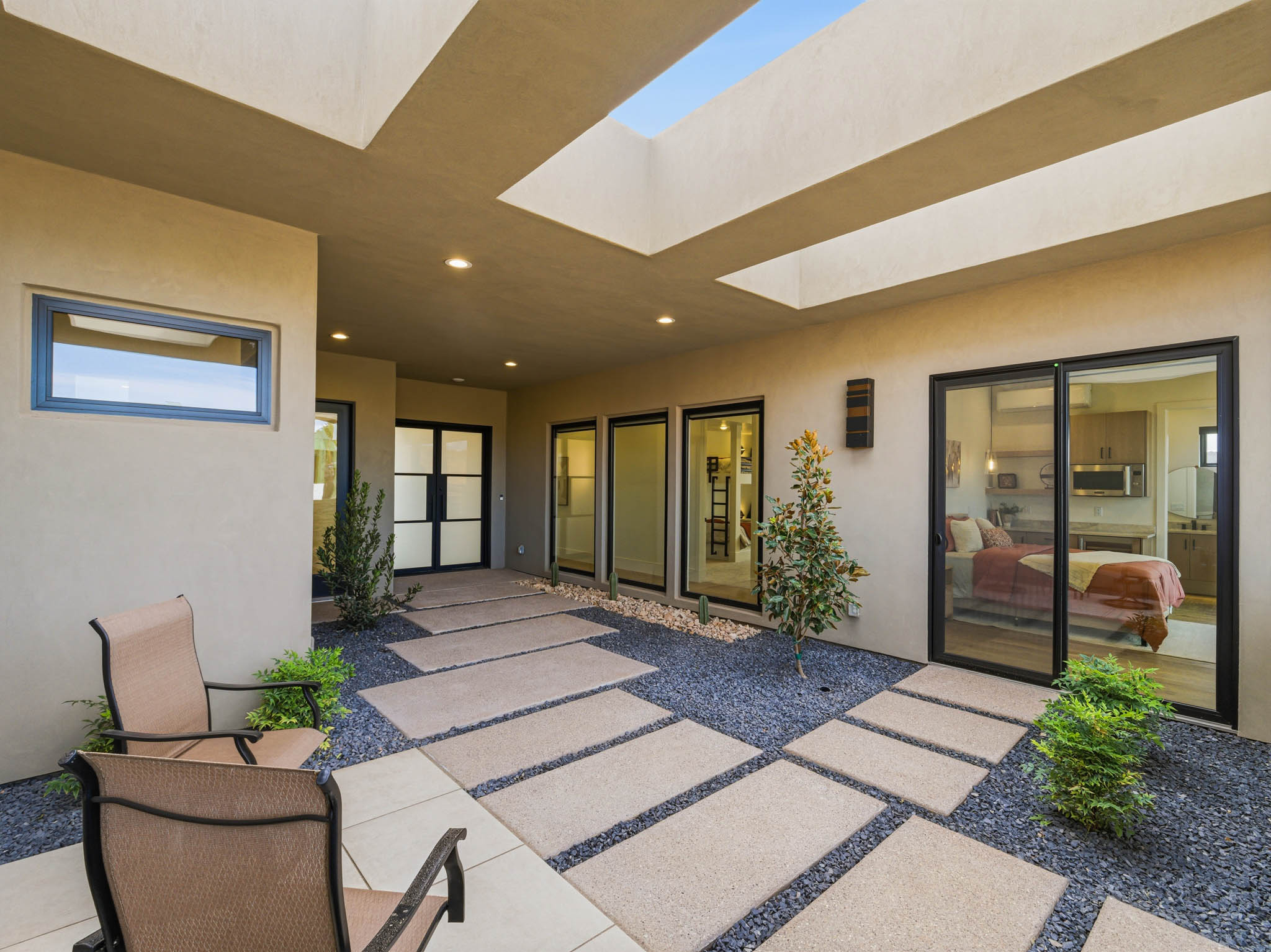 A covered courtyard with skylights, large windows, and indoor-outdoor living spaces